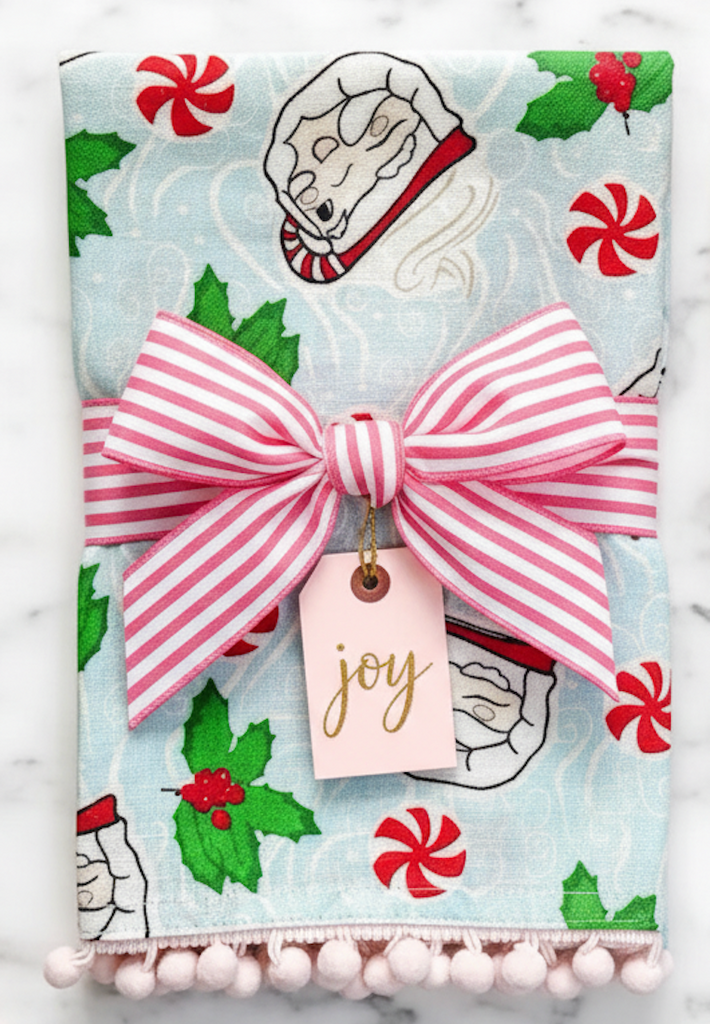 blue tea towel with vintage winking santa mugs, holly and starlite candies wrapped in a pink and white bow