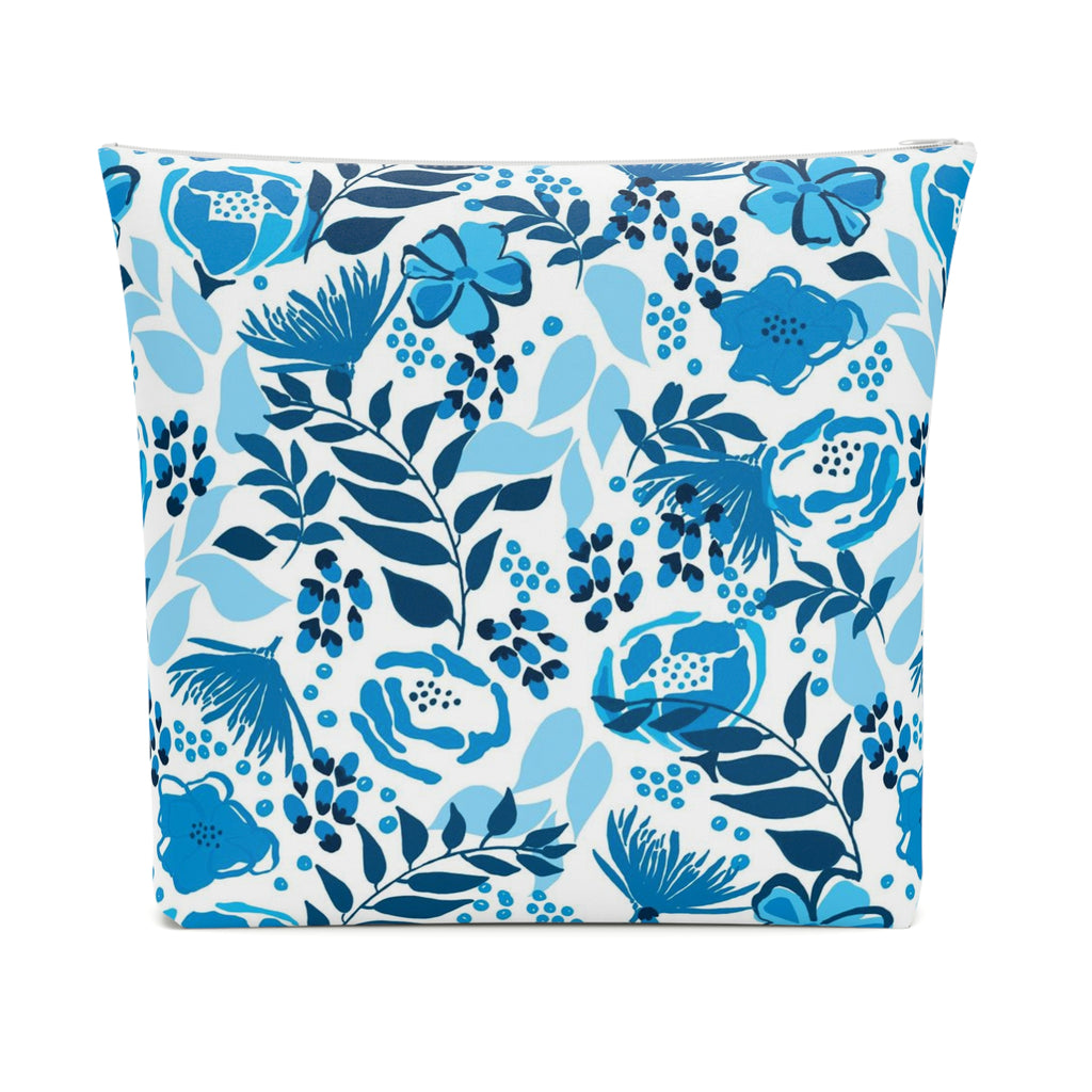 Cosmetic bag with white zipper and a blue floral design with flowers and leafy stems on a white background