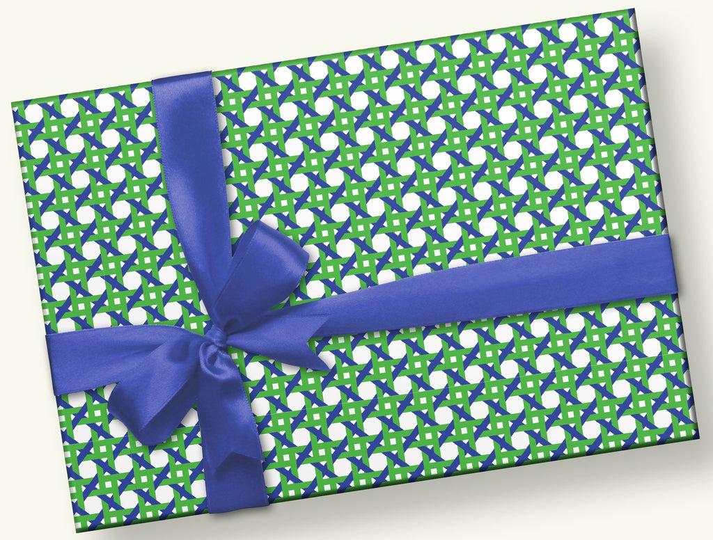 This is a rectangular gift with a navy blue satin bow.  The gift wrap pattern  is a hand designed caning pattern with intricate geometric designs in shades of blue and green