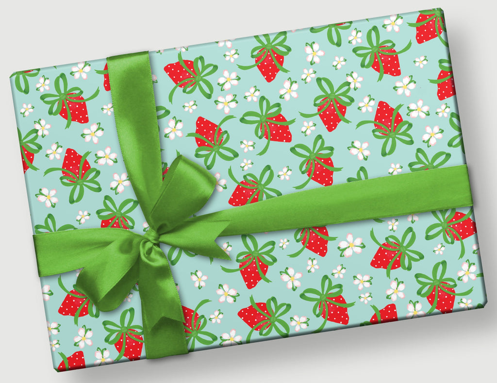 Rectangular gift with green bow and strawberries on a light blue background and white flowers.  The strawberries have bows for leaves